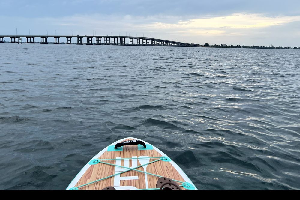 View across the Indian River Lagoon from a paddleboard, with the Eau Gallie Causeway bridge on the horizon.